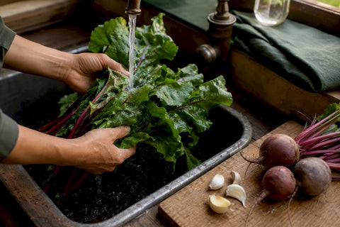 Fresh leafy greens rinsed in a kitchen sink